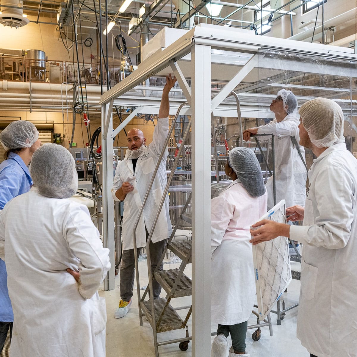 A group of people within a temporary cleanroom under construction